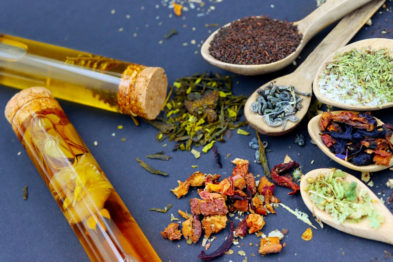 Menu Colorful assortment of loose leaf teas and spices displayed on wooden spoons with test tubes.